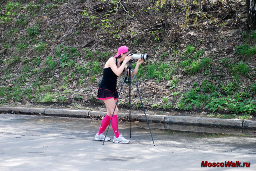девушка-фотограф снимает марафон